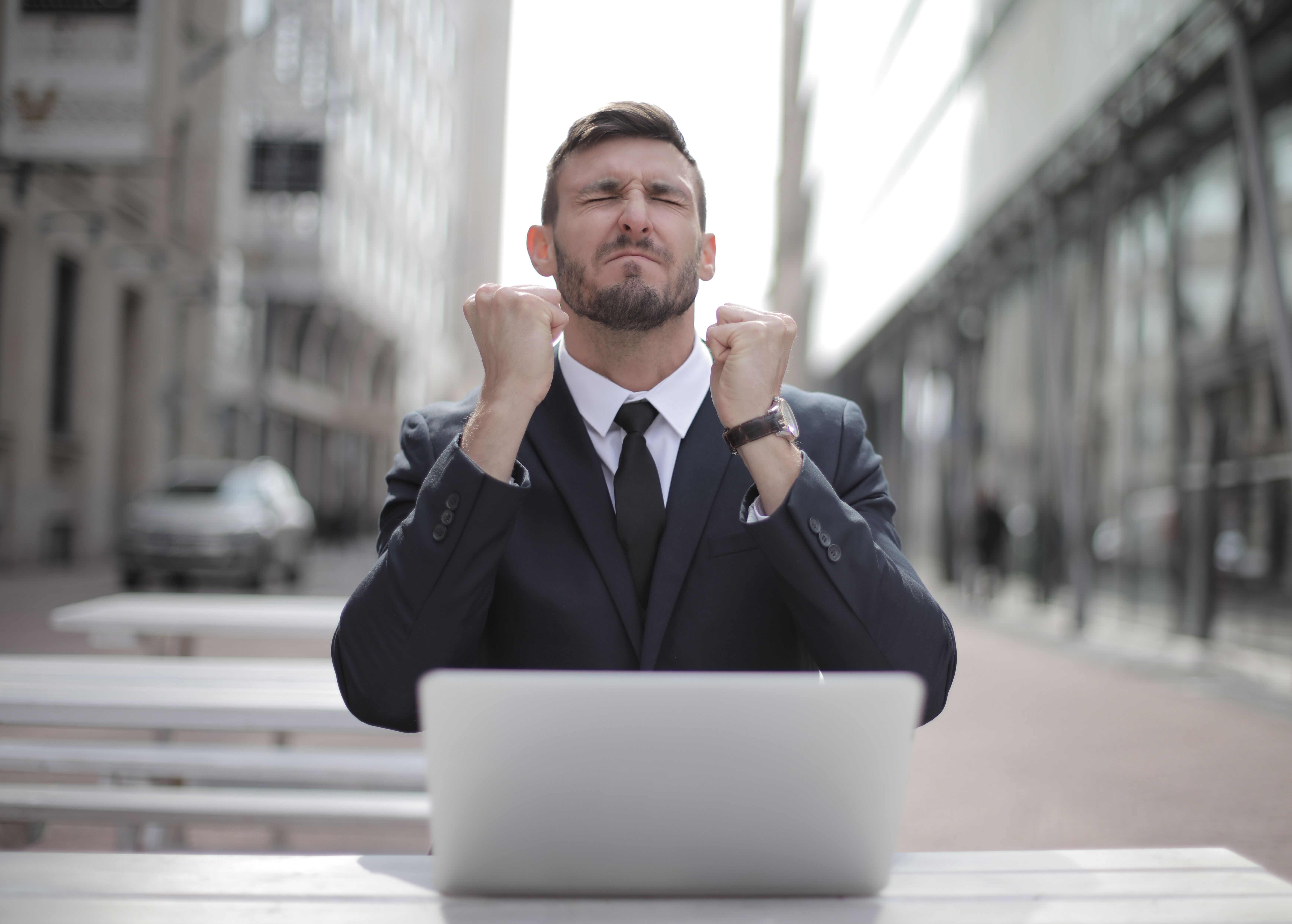 Businessman celebrating in front of laptop